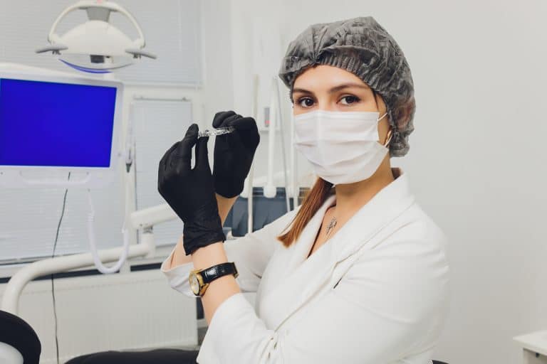 Zahnärztin hält Aligner in die Kamera - Invisalign Attachments