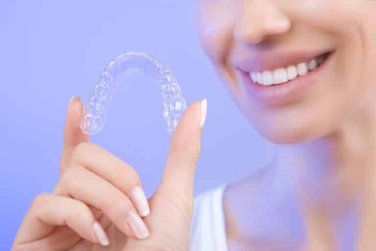 Junge Frau hält Aligner in der Hand - DrSmile vs Braceless