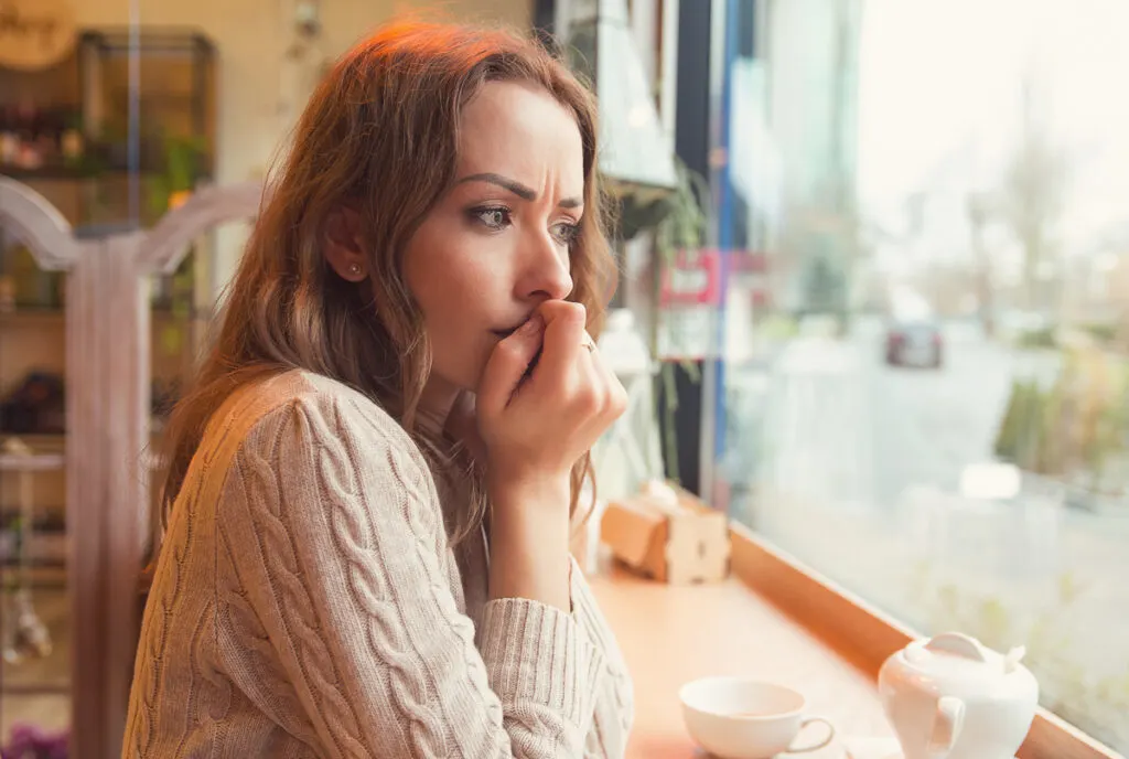 Une jeune femme réfléchit dans un café - traiter la sous-occlusion