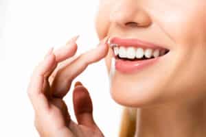 Young Woman pointing at her beautiful Teeth