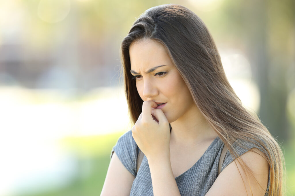 Mujer en pose pensativa - corrección dental para adultos