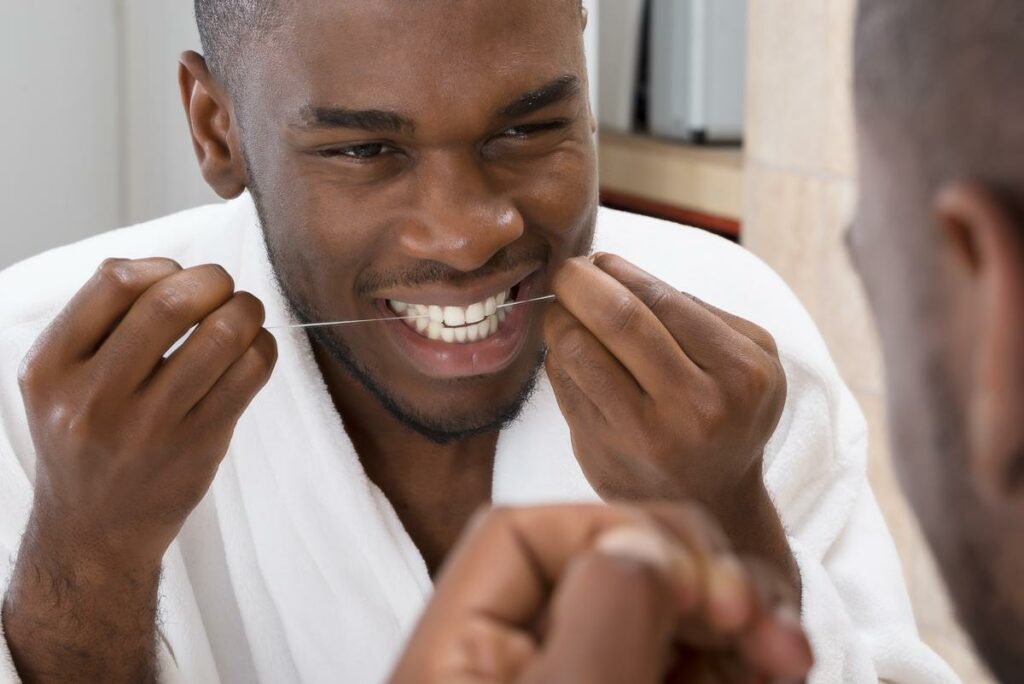 Un hombre utiliza hilo dental